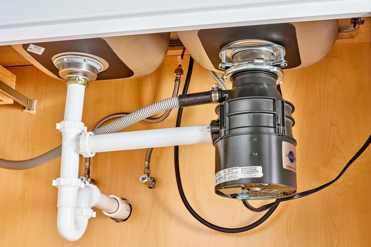 Under-sink garbage disposal — InSinkErator unit installed and plumbed in a San Diego kitchen
