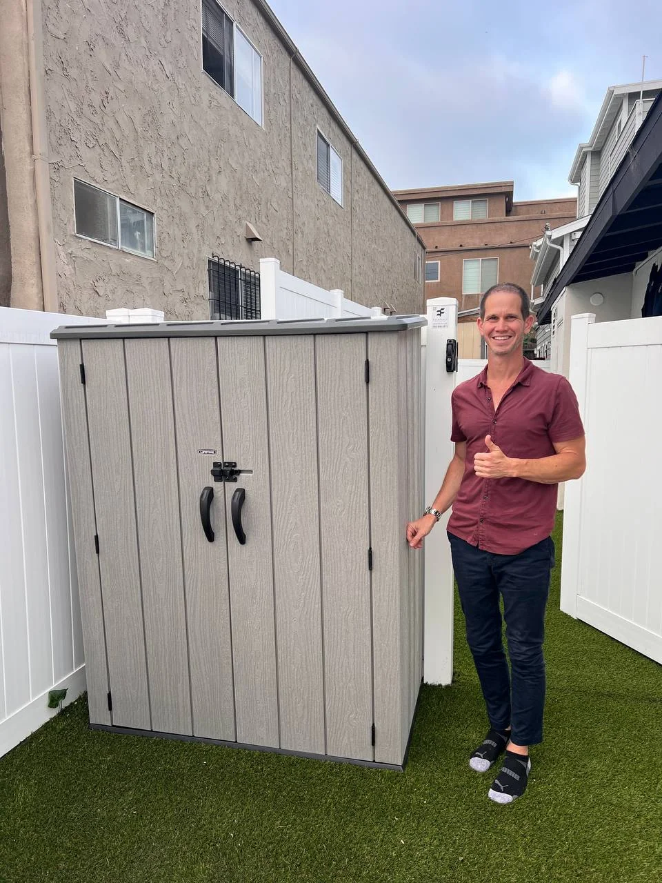 Christian G., Easy Break Service customer in San Diego, standing next to his newly-assembled Lifetime outdoor storage shed