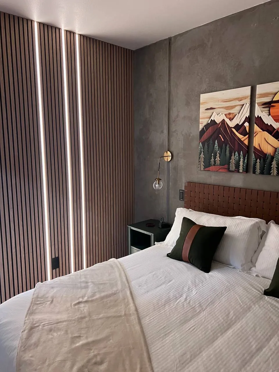 Bedroom wood-slat feature wall with framed art