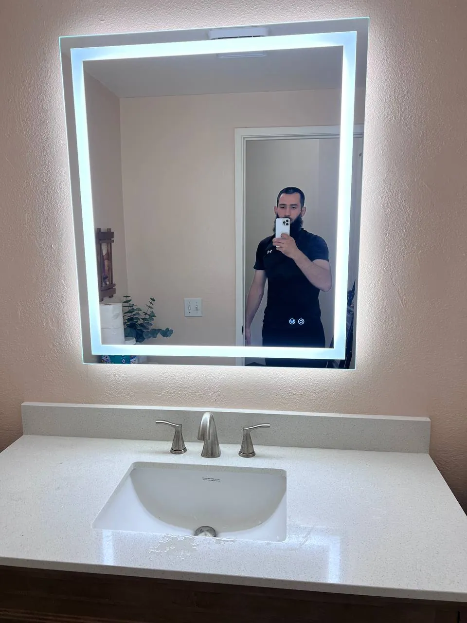 Backlit LED mirror over a floating vanity in a San Diego bathroom