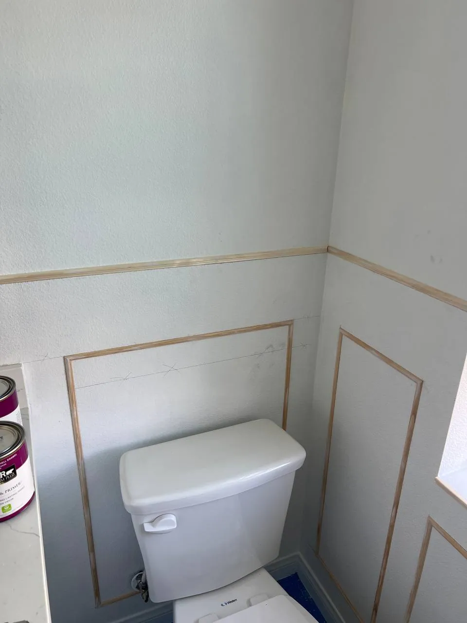 Toilet and board-and-batten wainscoting in a remodeled bath