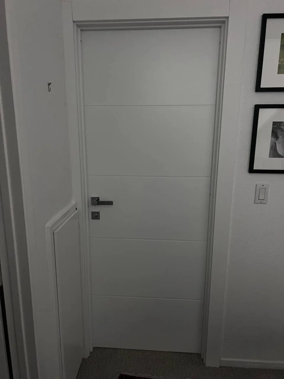 White interior doors along a framed-art hallway