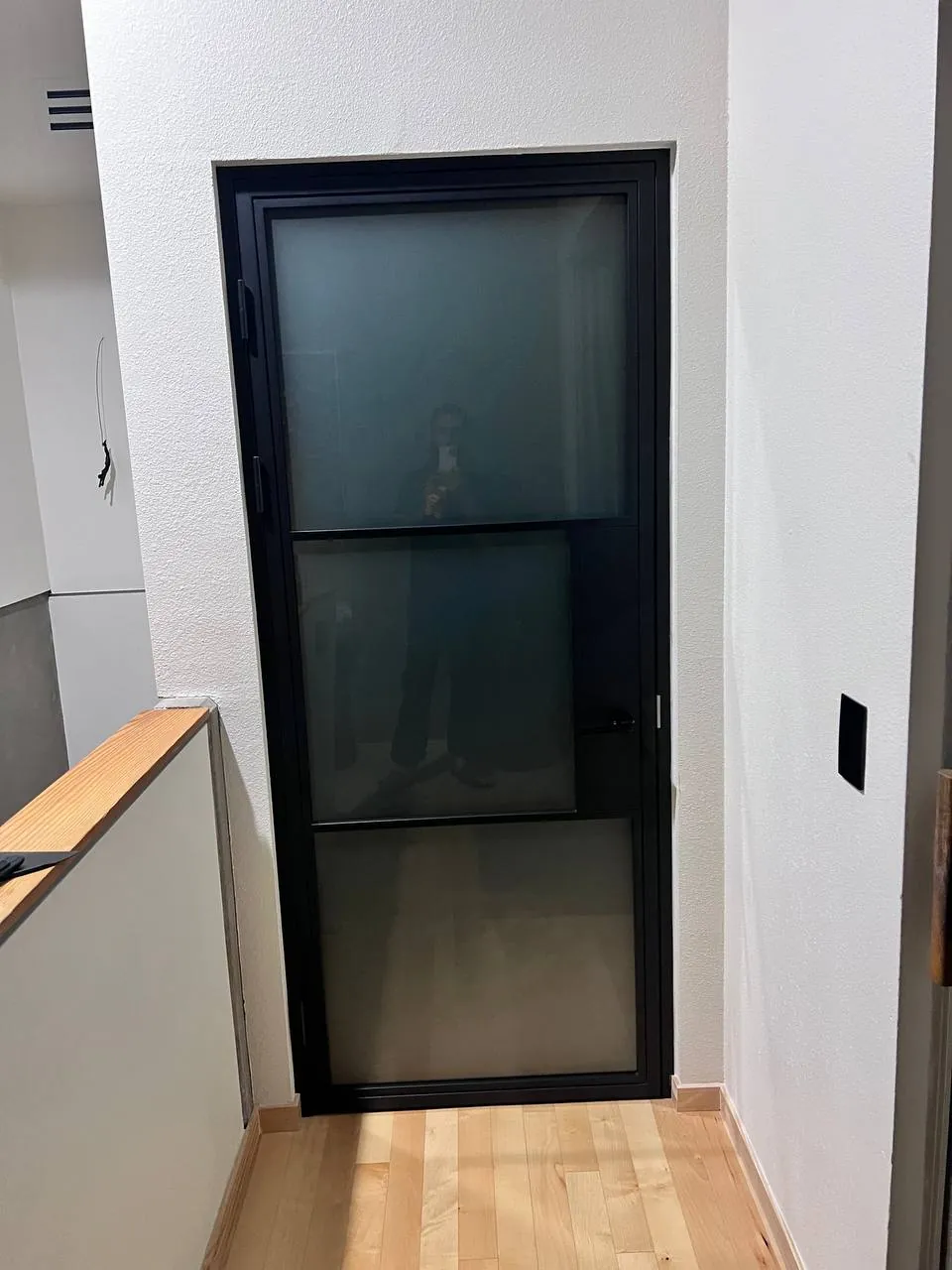 Black-framed glass sliding door to a stairwell