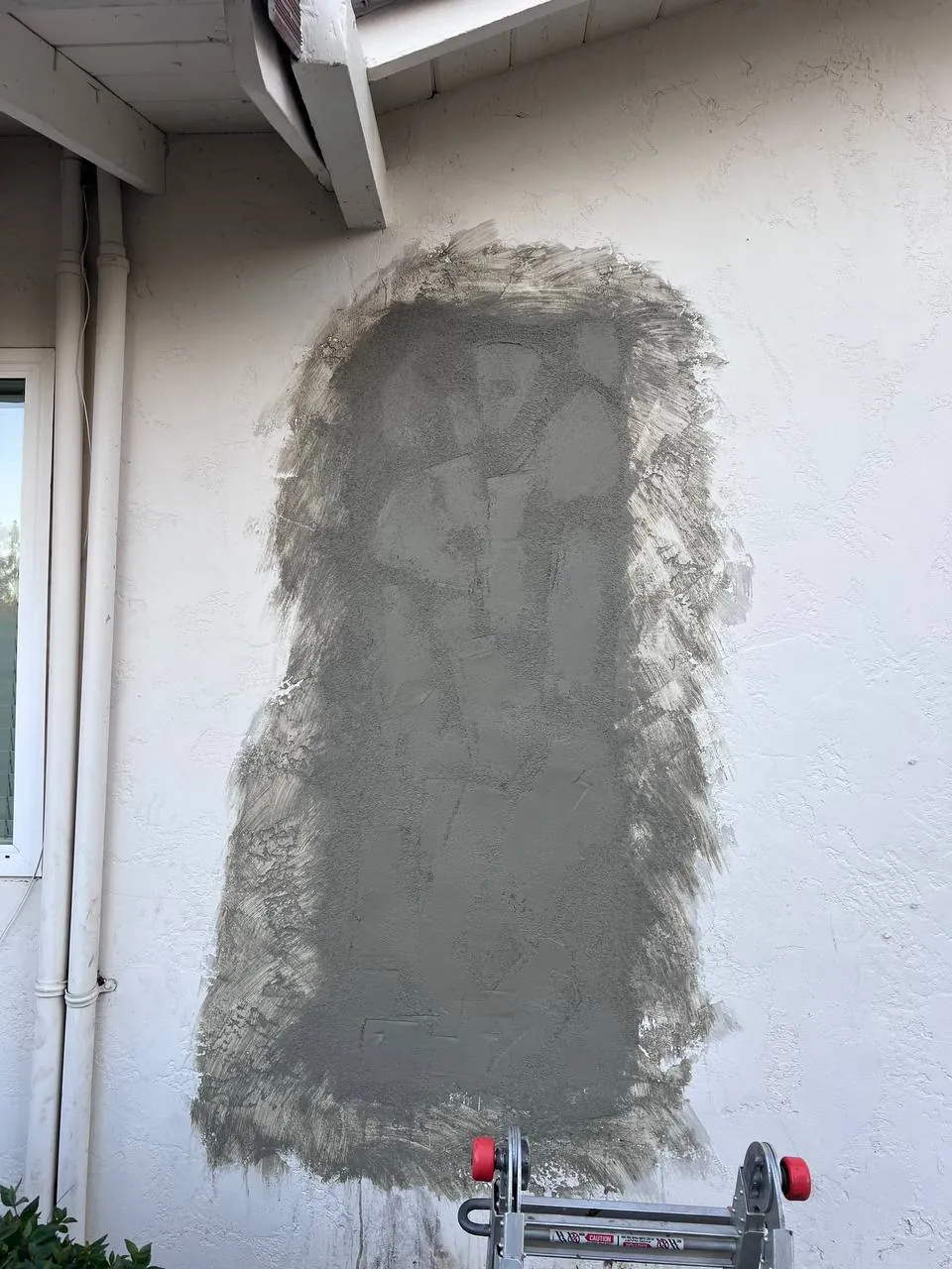 Drywall hole being patched with fresh joint compound