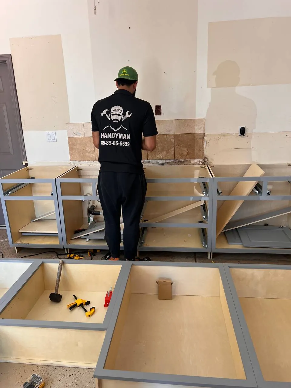 Handyman assembling flat-pack furniture on site