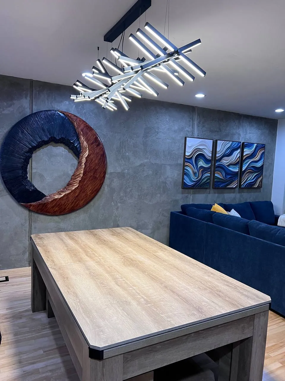 Sculptural modern chandelier installed over a wood table