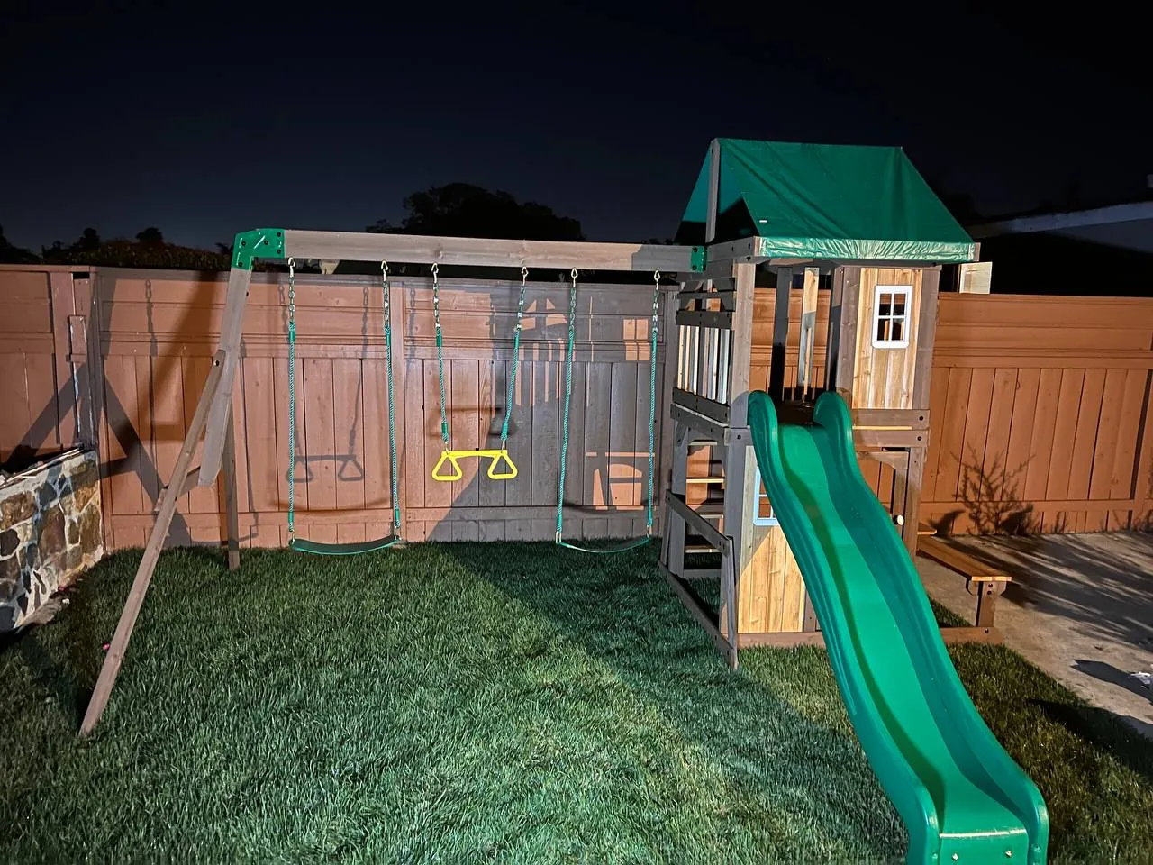 Wooden swing set and playset fully assembled in a backyard