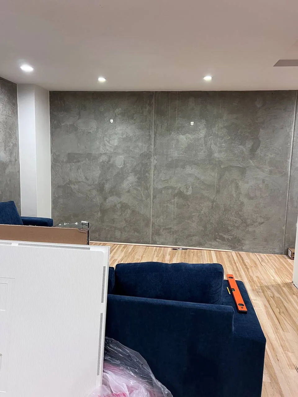 TV mounted on a concrete accent wall in a San Diego living room