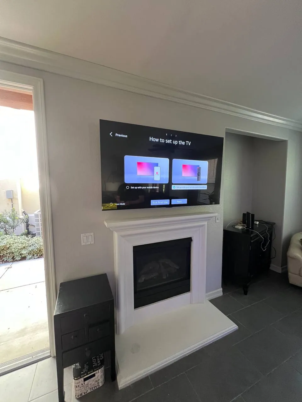 TV mounted above a white fireplace with built-in cabinets