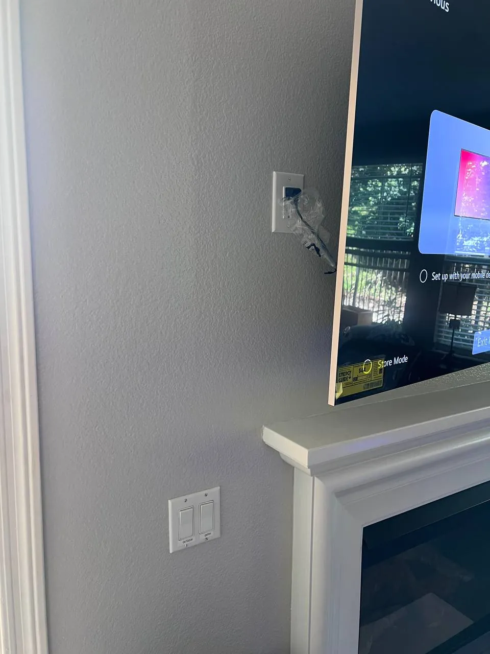 Flat-screen TV mounted above a fireplace mantel